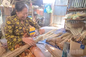 Các thợ làm chổi ở Làng nghề bó chổi cọng dừa Vĩnh Chánh vẫn duy trì cách làm truyền thống.