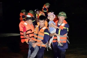 Công an Thanh Hóa di chuyển trẻ em khỏi nơi ngập nước.