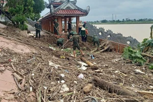 Cán bộ, chiến sĩ Ban Chỉ huy Phòng thủ Khu vực 4-Triệu Phong dọn dẹp rác và bùn tại Bến thả hoa bờ nam sông Thạch Hãn.
