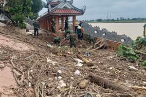 Cán bộ, chiến sĩ Ban Chỉ huy Phòng thủ Khu vực 4-Triệu Phong dọn dẹp rác và bùn tại Bến thả hoa bờ nam sông Thạch Hãn.