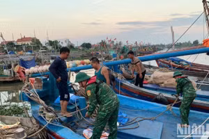 Cán bộ, chiến sĩ Đồn Biên phòng Đoàn Xá hỗ trợ ngư dân chằng buộc phương tiện phòng, chống bão Ragasa.