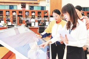 Cán bộ hướng dẫn người dân làm thủ tục hành chính tại bộ phận một cửa.