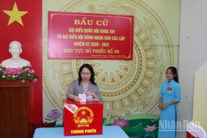 Đồng chí Võ Thị Ánh Xuân đại diện cử tri tiêu biểu của địa phương bỏ những lá phiếu đầu tiên vào thùng phiếu.