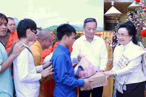 Bà Naly Sisoulith (bìa phải) trao quà cho người dân.