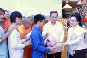 Bà Naly Sisoulith (bìa phải) trao quà cho người dân.