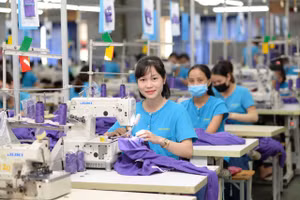 Công nhân nữ làm việc hứng khởi tại cơ sở sản xuất của Tổng công ty Cổ phần Dệt may Hà Nội (Hanosimex).