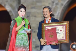 Họa sĩ Ngô Bá Hoàng nhận bằng công nhận kỷ lục. (Ảnh: NVCC)