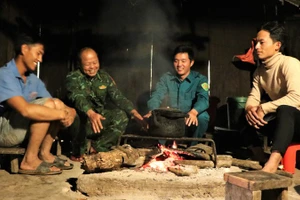 Anh Thò Bá Của (thứ hai, từ trái sang) và cán bộ Đồn Biên phòng Tri Lễ tuyên truyền quy định về bảo vệ đường biên, cột mốc tới dân bản.