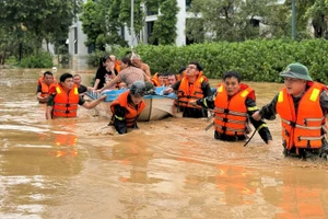 Cán bộ, chiến sĩ Công an tỉnh Nghệ An sơ tán người dân ra khỏi vùng nguy hiểm.