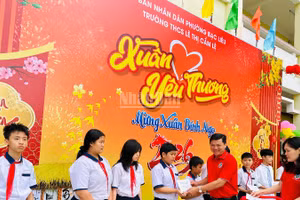 Thầy giáo Phan Thành Trung, Bí thư Chi bộ, Hiệu trưởng Trường trung học cơ sở Lê Thị Cẩm Lệ (phường Bạc Liêu, Cà Mau) trao quà Tết tặng các em học sinh có hoàn cảnh khó khăn. (Ảnh: TRỌNG DUY)