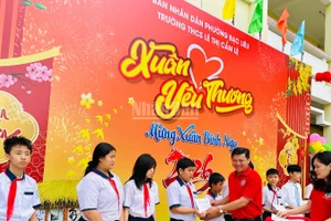 Thầy giáo Phan Thành Trung, Bí thư Chi bộ, Hiệu trưởng Trường trung học cơ sở Lê Thị Cẩm Lệ (phường Bạc Liêu, Cà Mau) trao quà Tết tặng các em học sinh có hoàn cảnh khó khăn. (Ảnh: TRỌNG DUY)