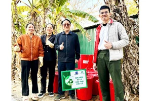 Trung úy Phạm Minh Hiếu (ngoài cùng bên phải) hướng dẫn người dân ủ rác hữu cơ thành phân bón vi sinh Bokashi.