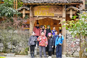 Anh Hiển (hàng dưới) chụp hình lưu niệm cùng du khách tại homestay của mình. 