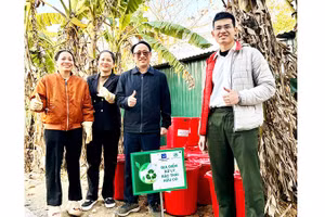 Trung úy Phạm Minh Hiếu (ngoài cùng bên phải) hướng dẫn người dân ủ rác hữu cơ thành phân bón vi sinh Bokashi.