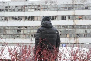 Một người đàn ông đang nhìn hướng về tòa nhà bị phá hủy bởi tên lửa và máy bay không người lái của Nga tại Thủ đô Kiev của Ukraine, ngày 9/1/2026. (Ảnh: Xinhua)