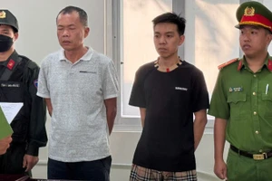 Đặng Trần Quốc Vũ (áo trắng) và Đào Năng Nghĩa (áo đen) tại cơ quan Công an. 