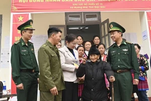 Đại tá Lê Đức Nghĩa cùng cán bộ, nhân dân xã Mường Nhé trò chuyện, động viên cử tri cao tuổi nhất tỉnh Điện Biên là cụ bà Trá Thị Dềnh ở bản Nậm Là 2, xã Mường Nhé.