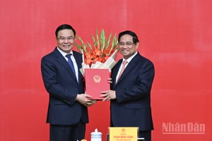 Thủ tướng Phạm Minh Chính trao Quyết định bổ nhiệm và tặng hoa chúc mừng đồng chí Lê Mạnh Hùng.