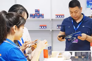 Khách hàng dùng điện thoại truy xuất thông tin hàng hóa qua mã QR .Ảnh: NAM ANH