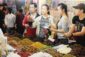 Người tiêu dùng lựa chọn các loại bánh mứt kẹo được bán trên thị trường. Ảnh: NGUYỆT ANH