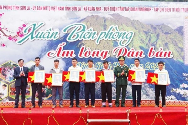 Lãnh đạo Ban Chỉ huy Bộ đội Biên phòng tỉnh Sơn La và lãnh đạo xã Xuân Nha tặng ảnh Bác Hồ, cờ Tổ quốc cho các bản biên giới.