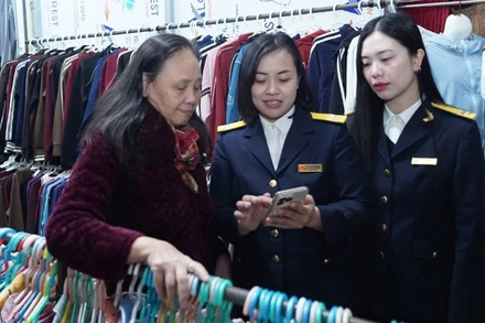 Cán bộ Thuế thành phố Hà Nội hướng dẫn hộ kinh doanh thực hiện thủ tục kê khai thuế.