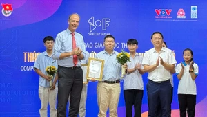 Đại diện nhóm tác giả dự án Mindvivo (ở giữa) nhận Giải Nhất tại Lễ trao giải cuộc thi.