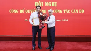 Đồng chí Đỗ Văn Chiến (bên phải) tặng hoa chúc mừng đồng chí Bùi Duy Đông.