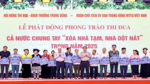 Thủ tướng Chính phủ Phạm Minh Chính và Chủ tịch Ủy ban Trung ương Mặt trận Tổ quốc Việt Nam Đỗ Văn Chiến (thứ 7 và thứ 10 từ phải sang) trao tượng trưng kinh phí hỗ trợ xóa nhà tạm, nhà dột nát tặng nhân dân. 