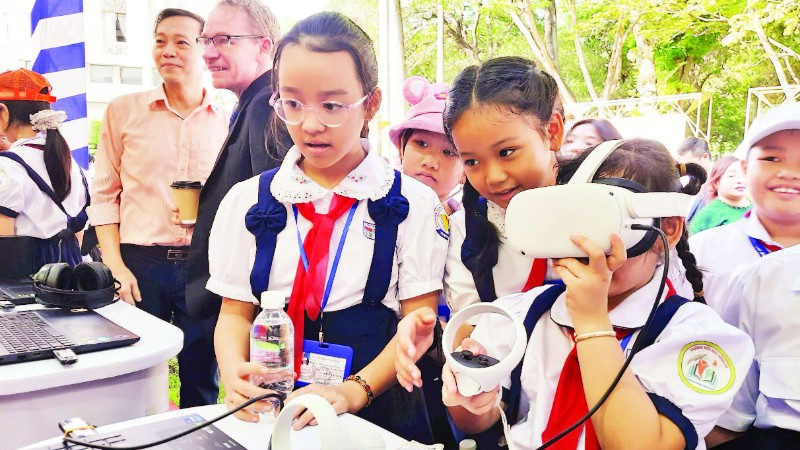 Học sinh tiểu học trải nghiệm thiết bị thực tế ảo trong hoạt động giáo dục STEM.