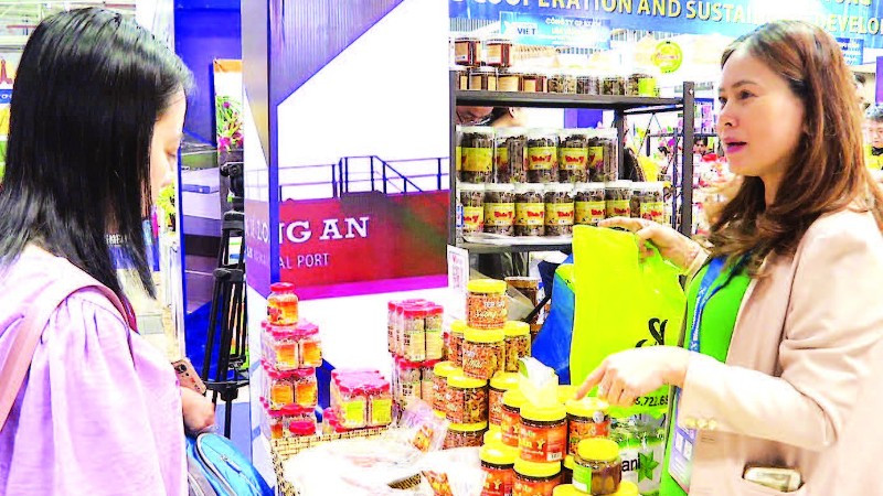 Doanh nghiệp giới thiệu mắm chua, mắm ruốc, muối tôm Chân Ý (Tây Ninh) tại một hội chợ. (Ảnh LAN NGỌC)