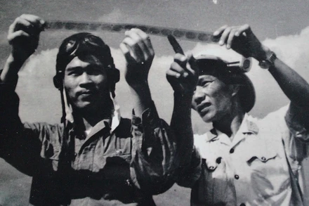 Phi công Nguyễn Văn Bảy (trái) cùng đồng đội xem lại những tấm phim do máy ảnh tự động chụp khi điểm hỏa. (Ảnh tư liệu)