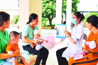 Cán bộ Trạm y tế xã Sảng Mộc, tỉnh Thái Nguyên tư vấn cho các bà mẹ về lợi ích khi tiêm vắc-xin cho trẻ.