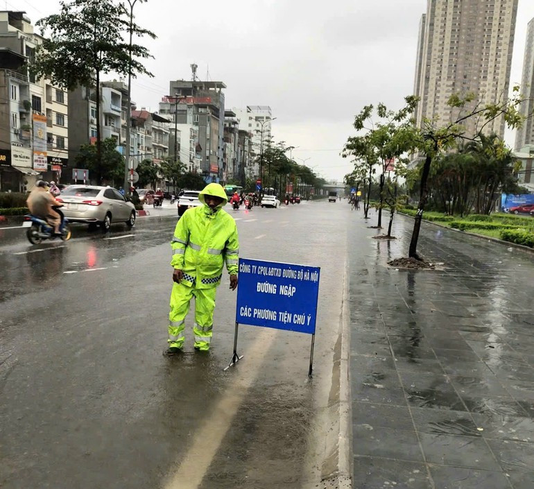 Nhiều tuyến đường bị ngập, Ban Duy tu các công trình hạ tầng giao thông đã bố trí người trực, hướng dẫn phương tiện. 33333.jpg