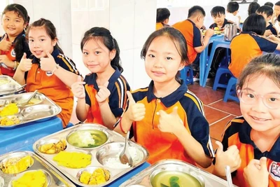 Giờ ăn bán trú của học sinh tại Trường tiểu học Thăng Long. (Ảnh NGỌC MINH)