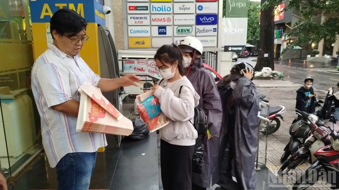 Dù trời mưa nhẹ nhưng nhiều độc giả vẫn đến đón nhận phụ san của Báo Nhân Dân. ndo_br_20.jpg