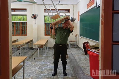 Lực lượng Công an tham gia vận chuyển bàn, ghế ở trường học lên chỗ cao.