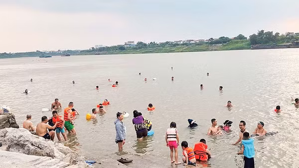 Nhiều gia đình mang cả trẻ nhỏ ra sông bơi lội dù không đủ các điều kiện an toàn.