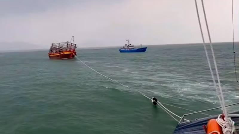 Tàu cứu nạn lai dắt tàu cá bị nạn vào bờ. (Ảnh: Bộ đội Biên phòng cung cấp)