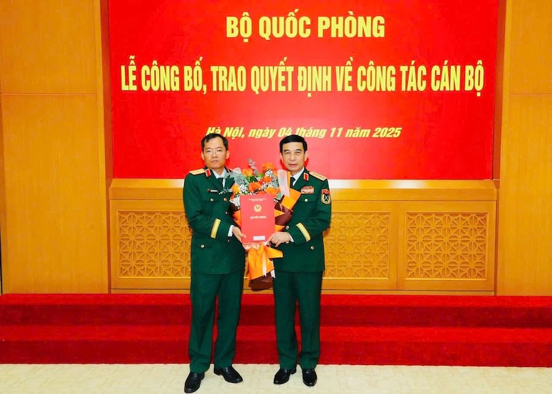 Thừa ủy quyền của Chủ tịch nước, thay mặt Quân ủy Trung ương, Bộ Quốc phòng, Đại tướng Phan Văn Giang trao Quyết định, tặng hoa chúc mừng Thiếu tướng Lương Đình Chung. (Ảnh: Quân khu 5 cung cấp)
