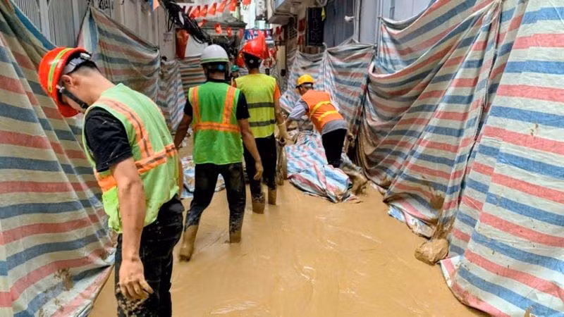 Công nhân dùng bao cát và bạt để che chắn hạn chế lượng bùn phun trào lên mặt đất. (Ảnh: Người dân cung cấp)