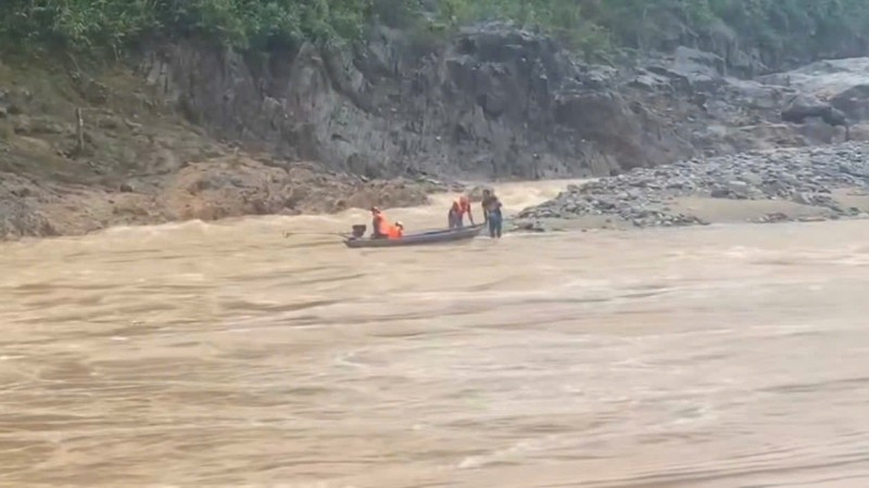 Lực lượng chức năng sử dụng xuồng máy tiếp cận khu vực hai người dân mắc kẹt, đưa họ về bờ. (Ảnh: địa phương cung cấp)