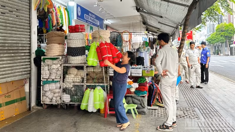 Lực lượng chức năng phường Hải Châu tuyên truyền, nhắc nhở các hộ kinh doanh khu vực chợ Hàn thu gọn hàng hóa, bảo đảm mỹ quan đô thị, sáng ngày 28/3. 
