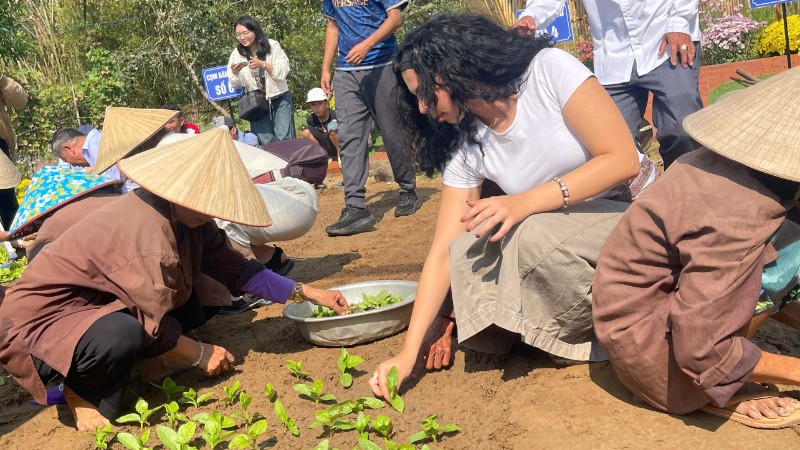 Du khách quốc tế tham gia trồng rau tại Lễ hội cầu bông Trà Quế, thành phố Đà Nẵng.