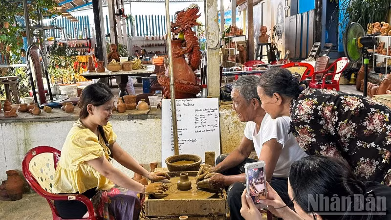 Du khách trải nghiệm làm gốm tại Làng gốm Thanh Hà. (Ảnh: ANH ĐÀO)