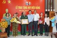 Bí thư Tỉnh ủy Đồng Tháp Lê Quốc Phong trao Huy hiệu 80 năm tuổi Đảng và tặng hoa chúc mừng đồng chí Thiếu tướng Lê Quang Viễn.