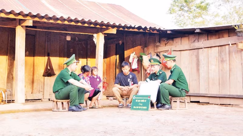 Cán bộ, chiến sĩ Đồn Biên phòng Nậm Nhừ, tỉnh Điện Biên trao gạo hỗ trợ hộ nghèo.