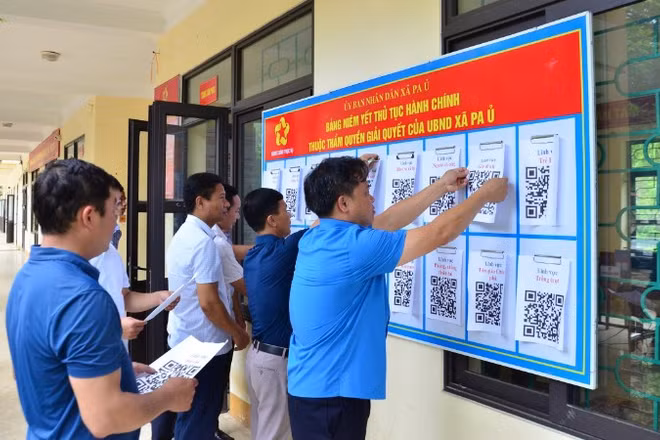 Cán bộ xã Pa Ủ triển khai niêm yết mã QR về thủ tục hành chính tại UBND xã, trụ sở được tận dụng từ trường THCS để làm việc.