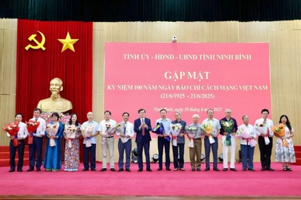 Đồng chí Đoàn Minh Huấn, Bí thư Tỉnh ủy Ninh Bình trao biểu trưng và tặng hoa chúc mừng các đồng chí lãnh đạo, nguyên lãnh đạo các cơ quan báo chí của tỉnh. (Ảnh: MINH QUANG)