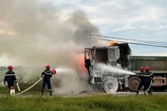 Lực lượng chuyên nghiệp sử dụng thiết bị chuyên dụng dập lửa khu vực cabin xe.